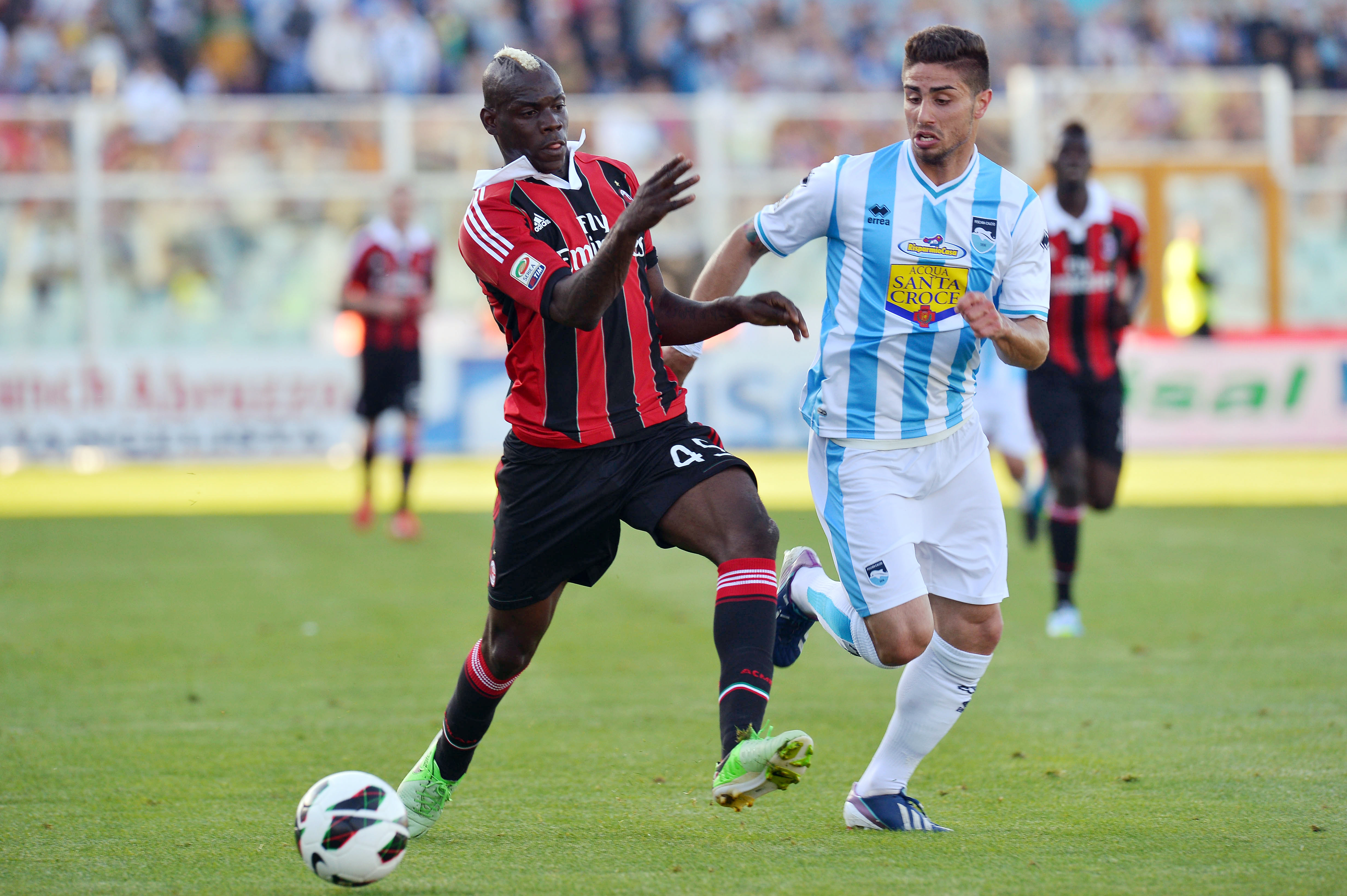 AC Milan's striker Mario Balotelli (L) vies with Pescara's Marco Capuano (R) during an Italian Serie A football match at the Adriaticum stadium in Pescara on May 8, 2013. AFP PHOTO / VINCENZO PINTO (Photo credit should read VINCENZO PINTO/AFP/Getty Images)