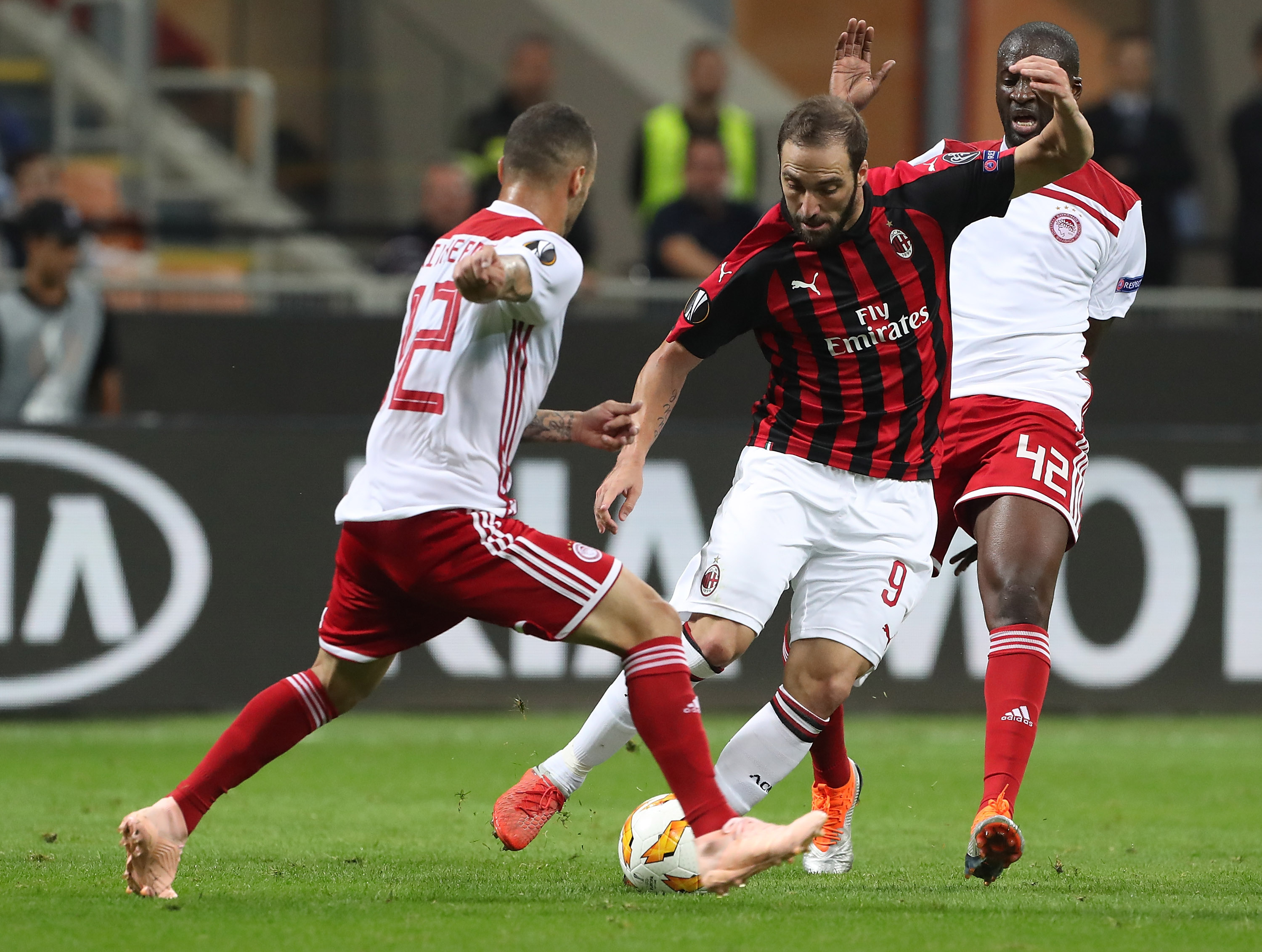 MILAN, ITALY - OCTOBER 04: Gonzalo Higuain (C) of AC Milan is challenged by Yaya Toure (R) and Guilherme (L) of Olympiacos during the UEFA Europa League Group F match between AC Milan and Olympiacos at Stadio Giuseppe Meazza on October 4, 2018 in Milan, Italy. (Photo by Marco Luzzani/Getty Images)
