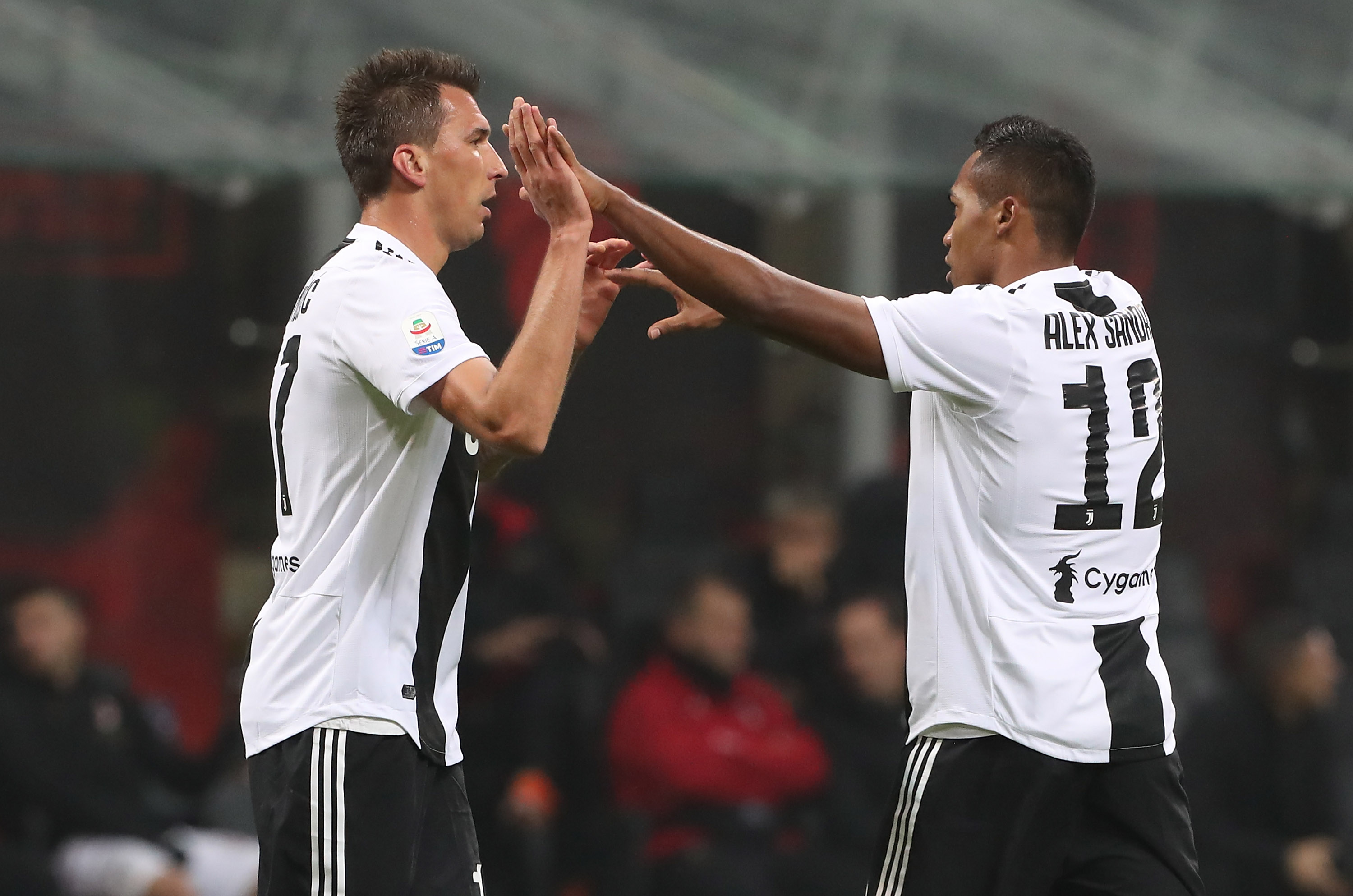 MILAN, ITALY - NOVEMBER 11: Mario Mandzukic (L) of Juventus FC celebrates with his team-mates Alex Sandro (R) after scoring the opening goal during the Serie A match between AC Milan and Juventus at Stadio Giuseppe Meazza on November 11, 2018 in Milan, Italy. (Photo by Marco Luzzani/Getty Images)