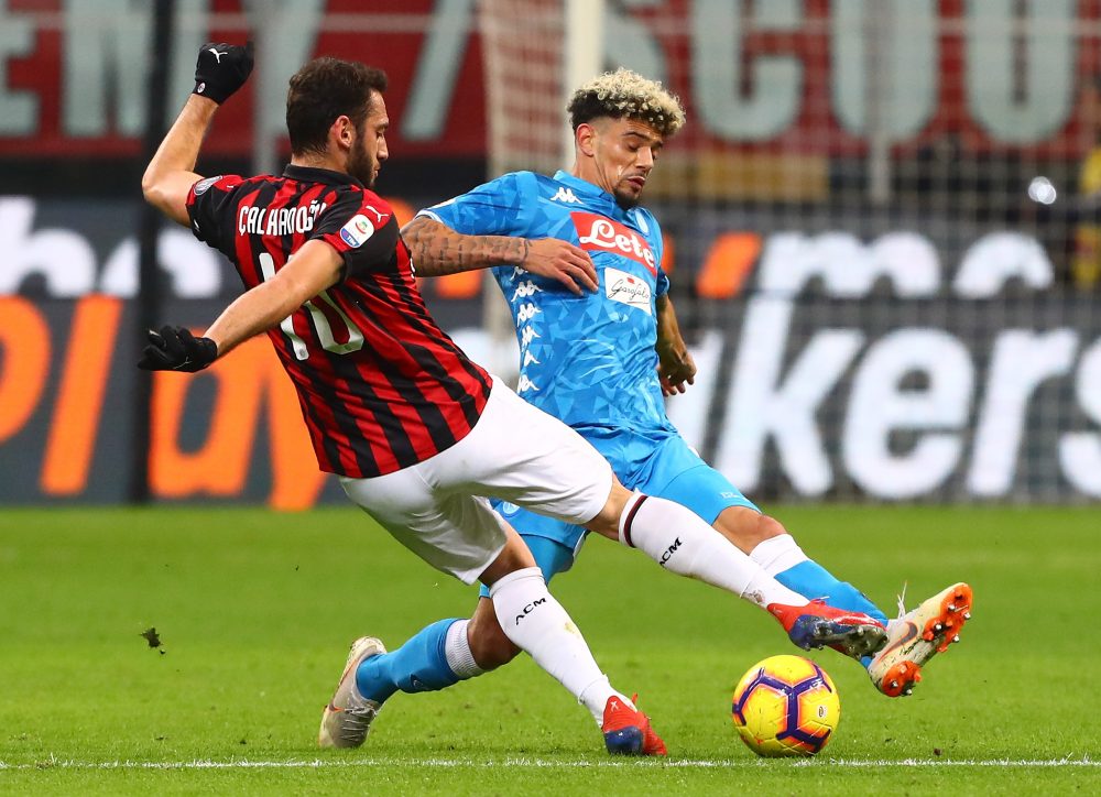 MILAN, ITALY - JANUARY 26: Hakan Calhanoglu of AC Milan is challenged by Kevin Malcuit (back) of SSC Napoli during the Serie A match between AC Milan and SSC Napoli at Stadio Giuseppe Meazza on January 26, 2019 in Milan, Italy. (Photo by Marco Luzzani/Getty Images)