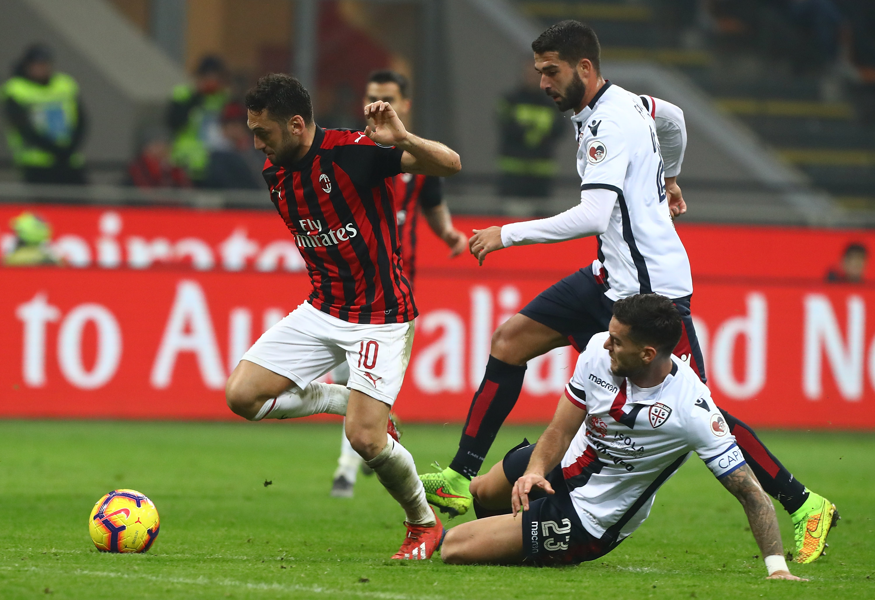 MILAN, ITALY - FEBRUARY 10: Hakan Calhanoglu of AC Milan competes for the ball with Luca Ceppitelli of Cagliari Calcio during the Serie A match between AC Milan and Cagliari at Stadio Giuseppe Meazza on February 10, 2019 in Milan, Italy. (Photo by Marco Luzzani/Getty Images)