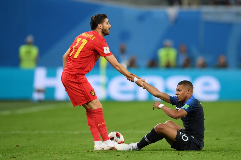 SAINT PETERSBURG, RUSSIA - JULY 10: Yannick Carrasco of Belgium helps Kylian Mbappe of France to his feet during the 2018 FIFA World Cup Russia Semi Final match between Belgium and France at Saint Petersburg Stadium on July 10, 2018 in Saint Petersburg, Russia. (Photo by Shaun Botterill/Getty Images)