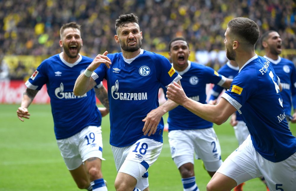 Schalke's German midfielder Daniel Caligiuri (2ndL) celebrates scoring with his team mates during the German First division Bundesliga football match BVB Borussia Dortmund v Schalke 04 in Dortmund, western Germany on April 27, 2019. (Photo by INA FASSBENDER / AFP) / DFL REGULATIONS PROHIBIT ANY USE OF PHOTOGRAPHS AS IMAGE SEQUENCES AND/OR QUASI-VIDEO (Photo credit should read INA FASSBENDER/AFP/Getty Images)