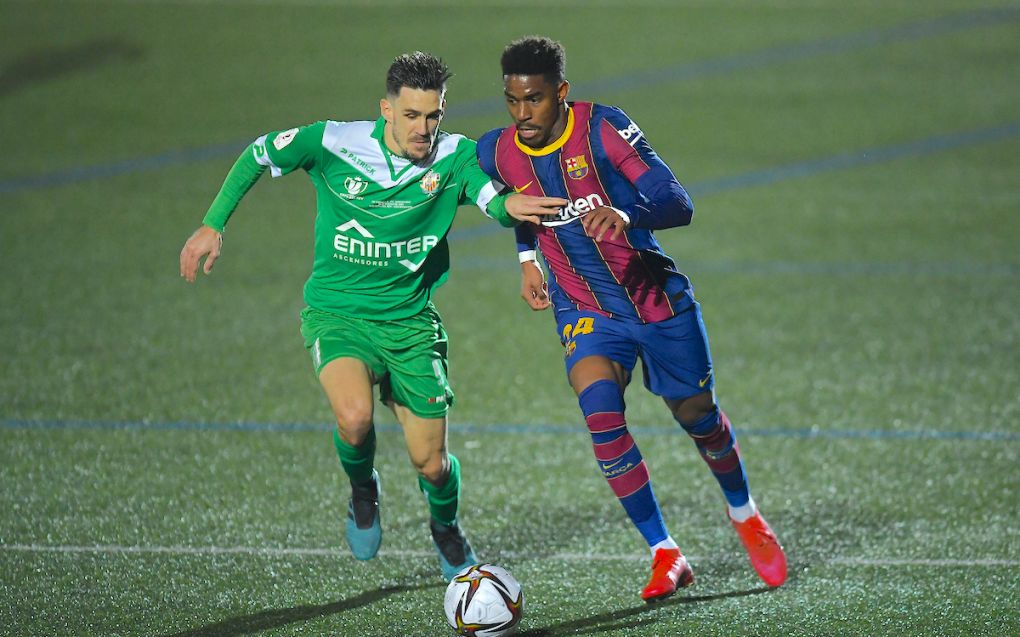 BARCELONA, SPAIN - JANUARY 21: Junior Firpo of Barcelona battles for possession with Ivan Guzman Garcia of Cornella during the Copa del Rey match between Cornella and FC Barcelona on January 21, 2021 in Barcelona, Spain. Sporting stadiums around Spain remain under strict restrictions due to the Coronavirus Pandemic as Government social distancing laws prohibit fans inside venues resulting in games being played behind closed doors. (Photo by Alex Caparros/Getty Images)