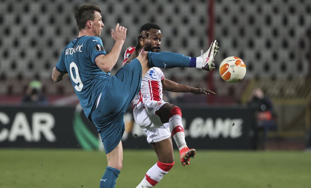 BELGRADE, SERBIA - FEBRUARY 18: Mario Mandzukic (L) of AC Milan competes for the ball against Guelor Kanga (R) of Crvena Zvezda during the UEFA Europa League Round of 32 match between Crvena Zvezda and AC Milan at on February 17, 2021 in Belgrade, Serbia. (Photo by Srdjan Stevanovic/Getty Images)