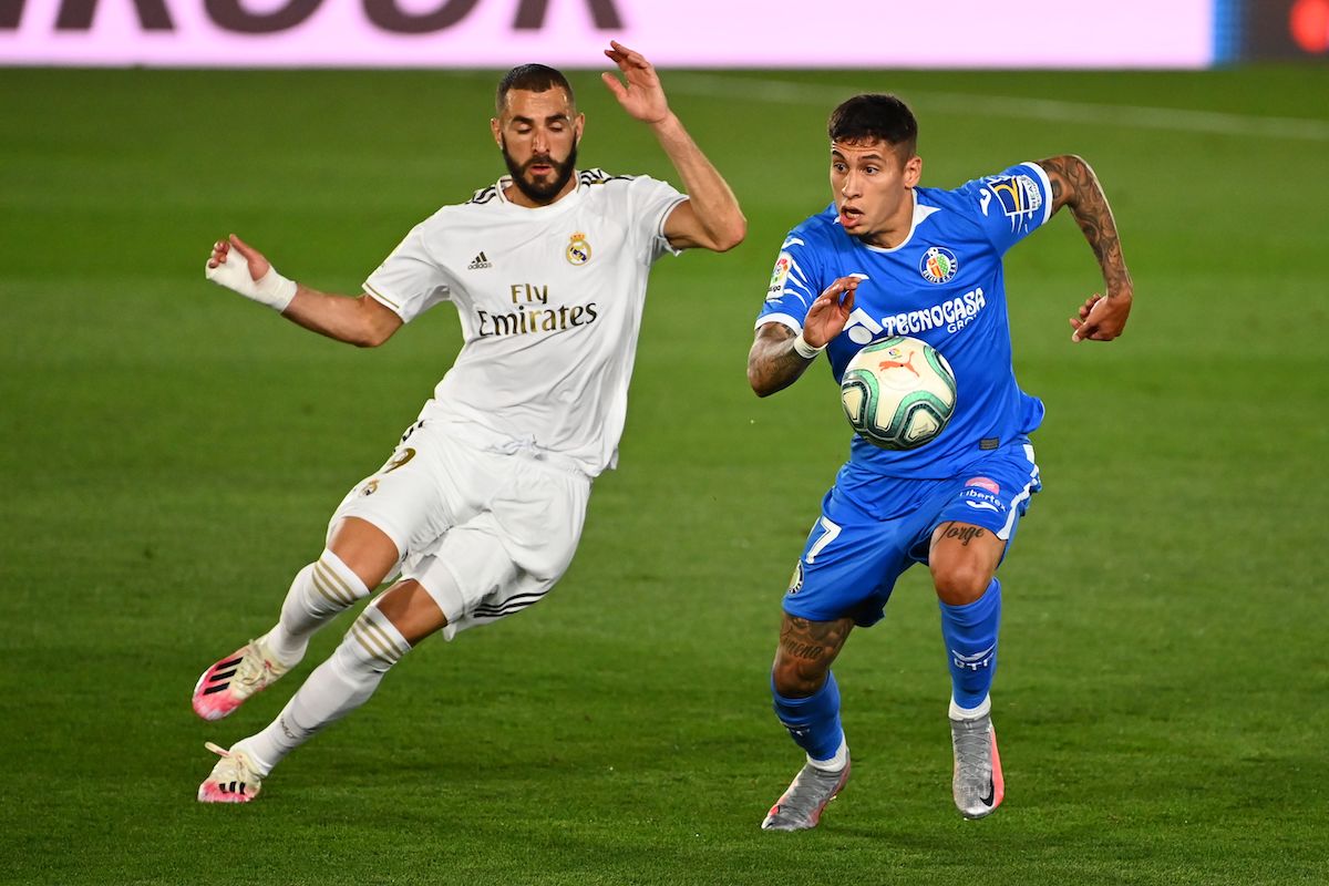 Real Madrid's French forward Karim Benzema (L) challenges Getafe's Uruguayan defender Mathias Olivera during the Spanish league football match Real Madrid CF against Getafe CF at the Alfredo di Stefano stadium in Valdebebas, on the outskirts of Madrid, on July 2, 2020. (Photo by GABRIEL BOUYS / AFP) (Photo by GABRIEL BOUYS/AFP via Getty Images)
