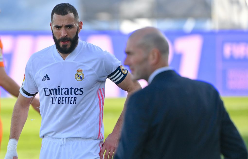 Real Madrid's French forward Karim Benzema (L) looks at Real Madrid's French coach Zinedine Zidane during the Spanish league football match between Real Madrid and Valencia at the Alfredo di Stefano stadium in Valdebebas on the outskirts of Madrid on February 14, 2021. (Photo by GABRIEL BOUYS / AFP) (Photo by GABRIEL BOUYS/AFP via Getty Images)