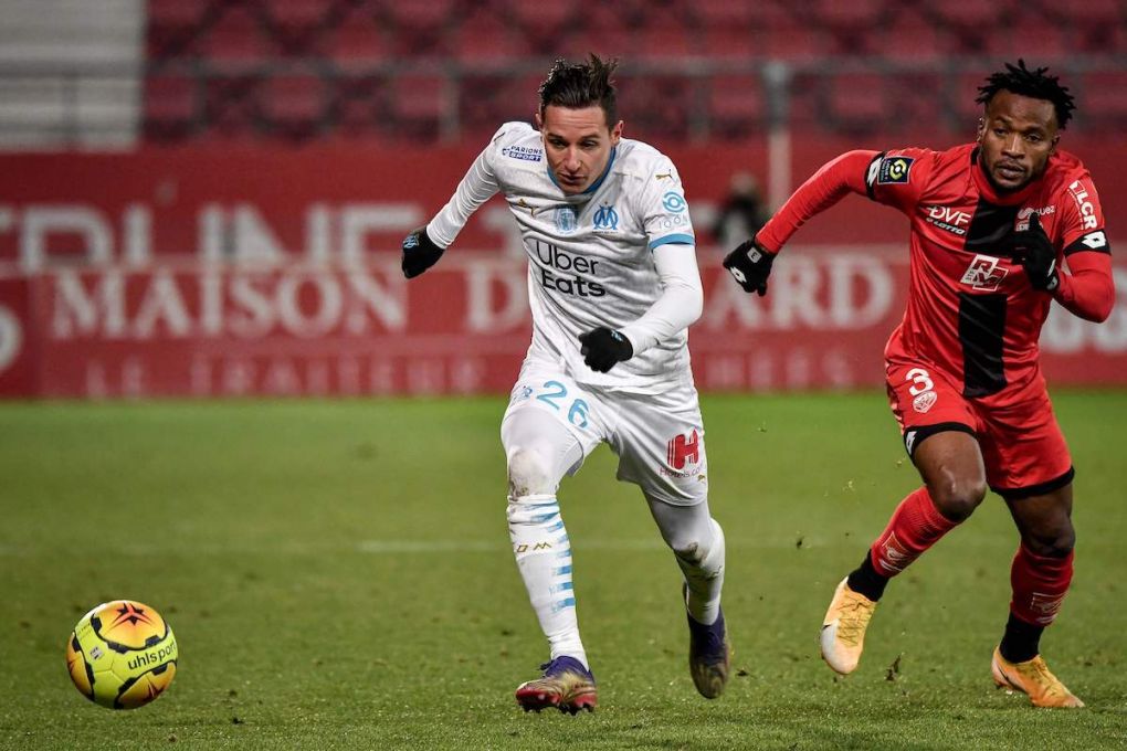 Marseille's French forward Florian Thauvin (L) and Dijon's Congolese defender Glody Ngonda run for the ball during the French L1 football match between Dijon FCO and Olympique de Marseille at the Gaston Gerard Stadium in Dijon, eastern France on January 9, 2021. (Photo by JEFF PACHOUD / AFP) (Photo by JEFF PACHOUD/AFP via Getty Images)