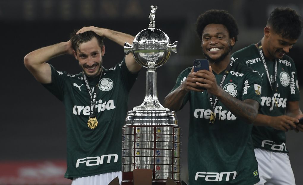 Palmeiras' Uruguayan Matias Vina (L) and teammate Luiz Adriano look at the trophy after winning the Copa Libertadores football tournament by defeating Santos in the all-Brazilian final match at Maracana Stadium in Rio de Janeiro, Brazil, on January 30, 2021. (Photo by Mauro PIMENTEL / POOL / AFP) (Photo by MAURO PIMENTEL/POOL/AFP via Getty Images)