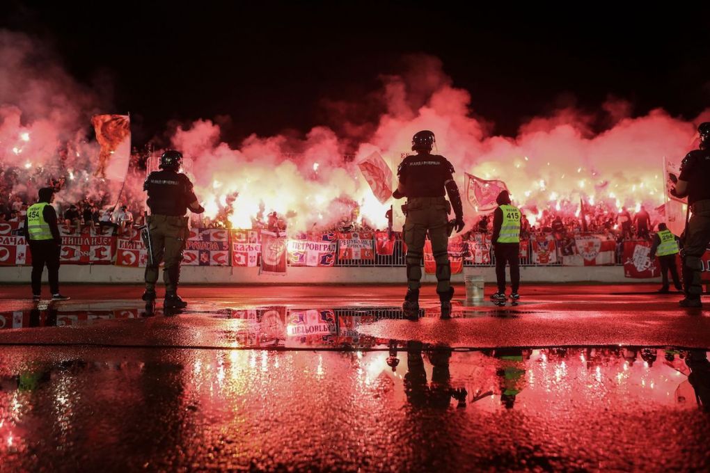 TOPSHOT - Stewards and security personnel stand as Red Star supporters light flares during the Serbian Cup semi-final football match between FK Partizan Belgrade and Red Star Belgrade (FK Crvena Zvezda) at the Partizan Stadium in Belgrade on June 10, 2020, as authorities allowed public gatherings and sports events resume in the country after being suspended in March with lockdown measures imposed to curb the spread of the COVID-19 pandemic, caused by the novel coronavirus. (Photo by Oliver BUNIC / AFP) (Photo by OLIVER BUNIC/AFP via Getty Images)