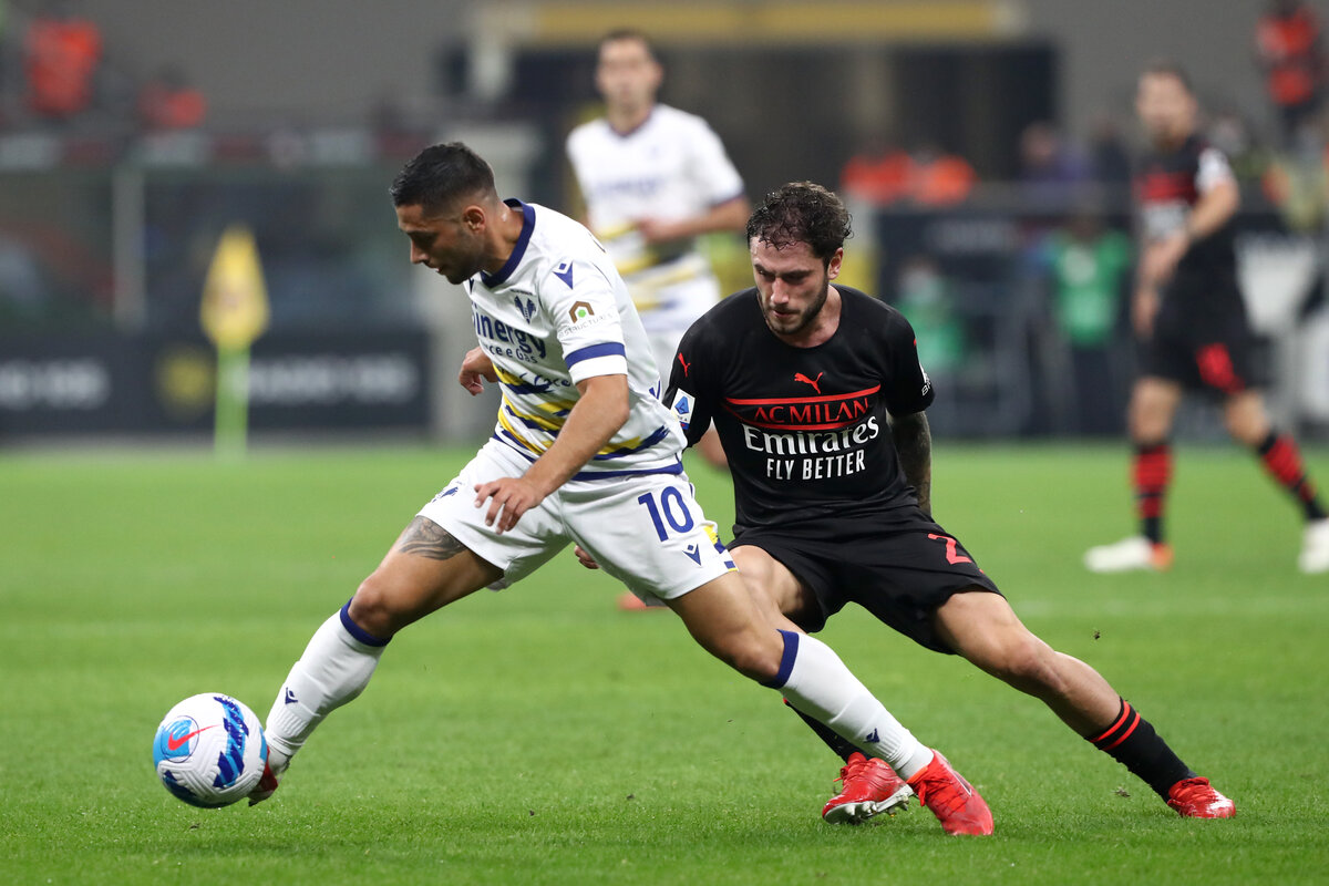 MILAN, ITALY - OCTOBER 16: Gianluca Capriari of Hellas Verona and Davide Calabria of AC Milan battle for the ball during the Serie A match between AC Milan and Hellas Verona FC at Stadio Giuseppe Meazza on October 16, 2021 in Milan, Italy. (Photo by Marco Luzzani/Getty Images)