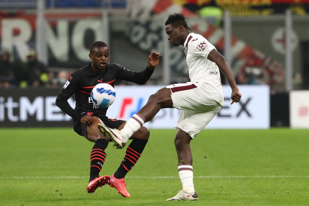 MILAN, ITALY - OCTOBER 26: Wilfried Singo of Torino FC and Pierre Kalulu of AC Milan battle for possession during the Serie A match between AC Milan and Torino FC at Stadio Giuseppe Meazza on October 26, 2021 in Milan, Italy. (Photo by Marco Luzzani/Getty Images)
