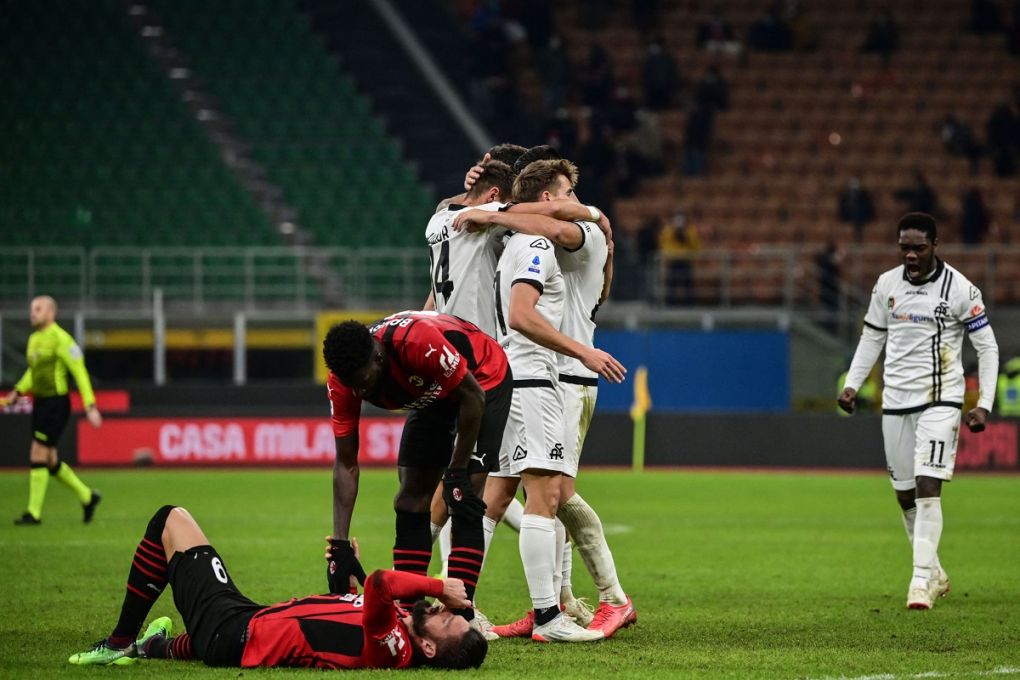 Spezia's Ghanaian forward Emmanuel Gyasi (R) and teammates (C) celebrates after scoring a last second winning goal, as AC Milan's French midfielder Tiemoue Bakayoko (C-L) comforts AC Milan's French forward Olivier Giroud (Bottom) during the Italian Serie A football match between AC Milan and Spezia on January 17, 2022 at the San Siro stadium in Milan. (Photo by MIGUEL MEDINA / AFP) (Photo by MIGUEL MEDINA/AFP via Getty Images)
