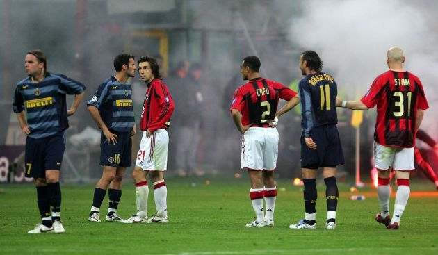 MILAN, ITALY - APRIL 12: Players from both teams look bemused as flares are thrown on to the pitch during the UEFA Champions League quarter-final second leg between Inter Milan and AC Milan at the San Siro Stadium on April 12, 2005 in Milan, Italy. (Photo by Mike Hewitt/Getty Images)
