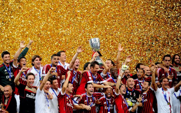 Football team players of AC Milan celebrate with the trophy after winning the Italian Super Cup 2011 match against Inter Milan