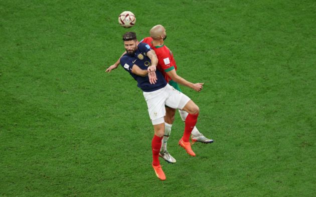 Olivier Giroud of France jumps for the ball with Sofyan Amrabat of Morocco