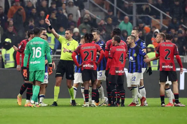 Match referee Andrea Colombo shows a red card to Theo Hernandez